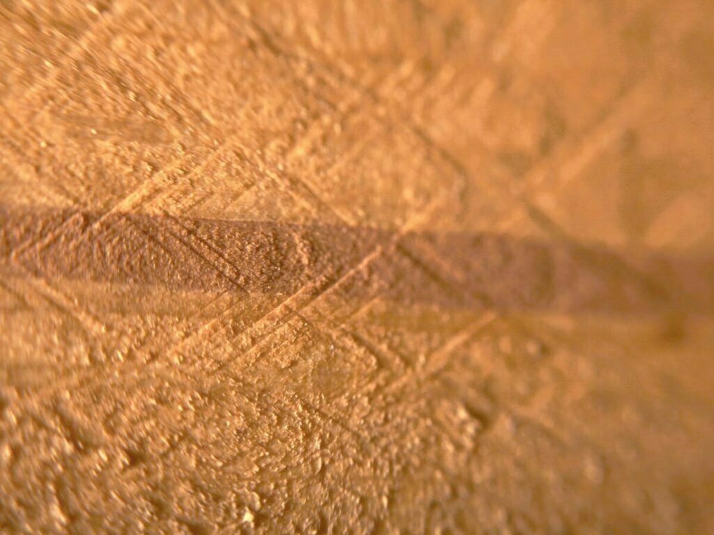 Ein Foto einer Markröhre, die sich durch das Holz zieht. Ein dunklerer, brauner Streifen geht von links nach rechts durch die Holzplatte.