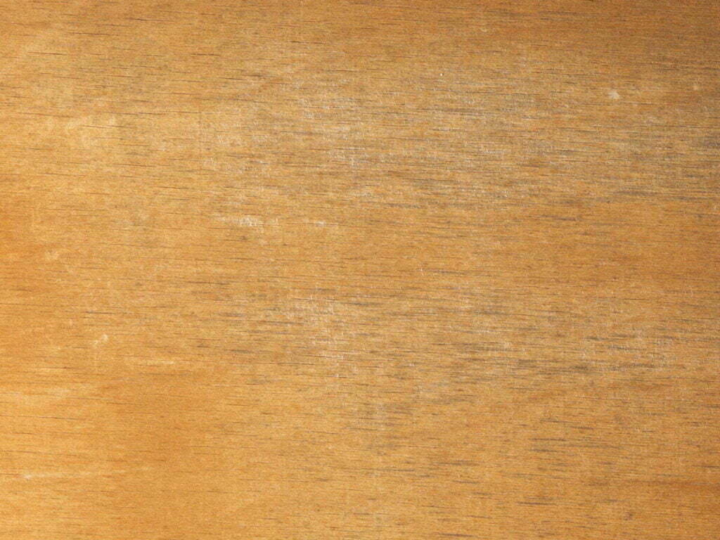 Ein Foto von Vergrauung im Holz. Streifen ziehen sich durch das Material, die der Maserung folgen.