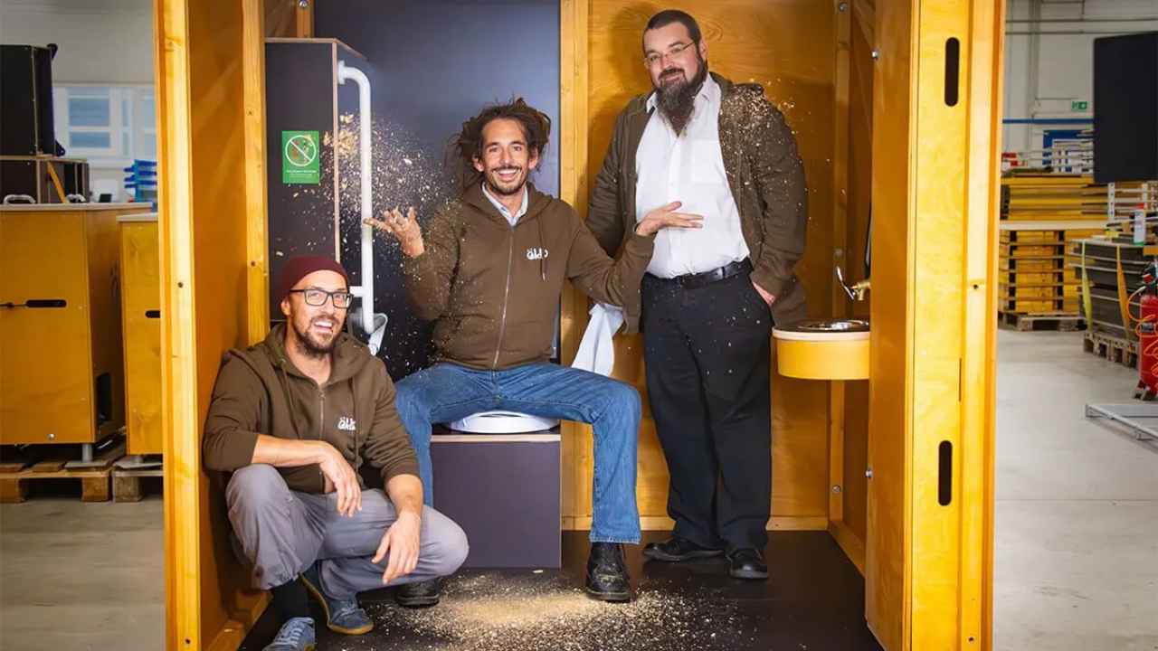 Gründer von öKlo vor einer wasserlosen öKlo Trockentoilette aus Holz.